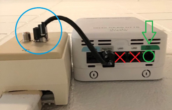 Photo example of wireless access point connected to wall and correct port to plug in device circled
